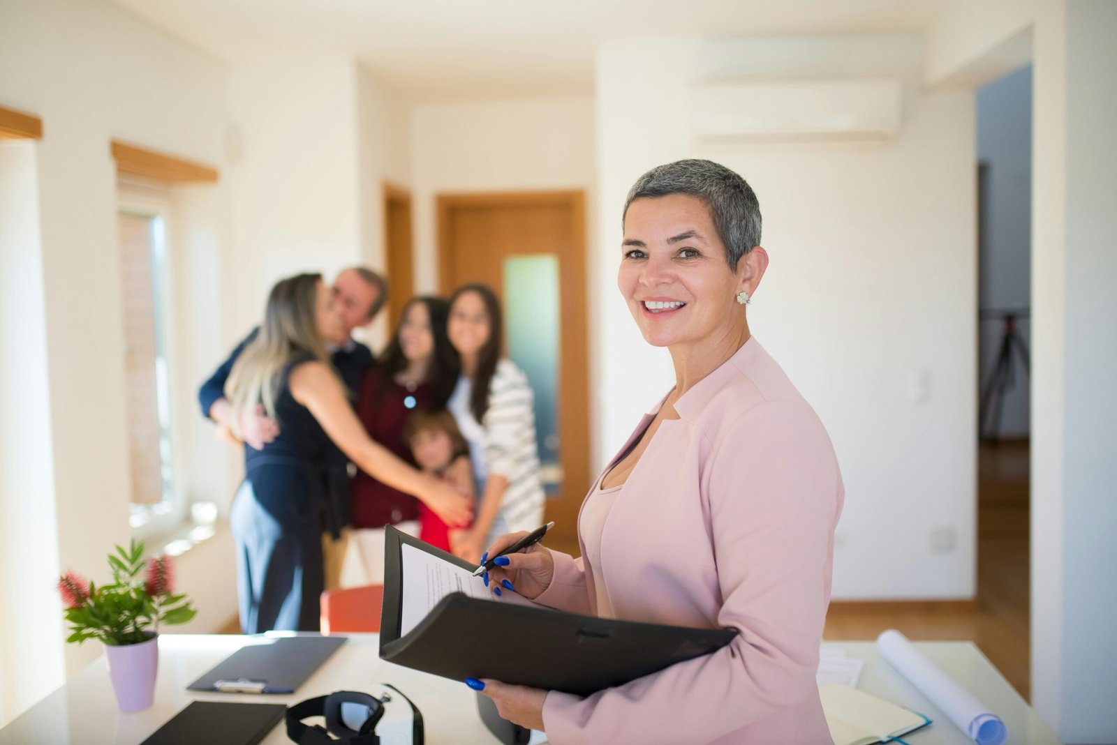 Confident real estate agent presents modern home to elated family, sealing the deal with a smile.